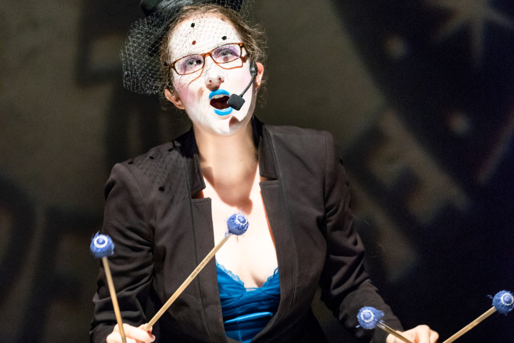 Closeup of Catherine playing vibraphone and singing