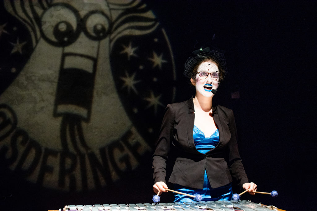 Catherine plays vibraphone with the San Diego Fringe logo spotlight staring ominously over her right shoulder